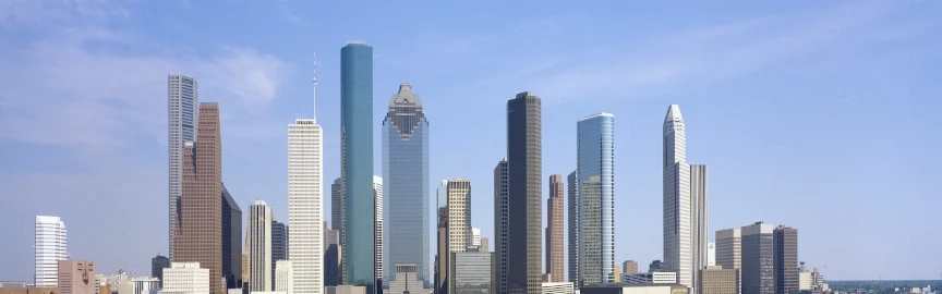 A city skyline with many skyscrapers under a blue sky.
