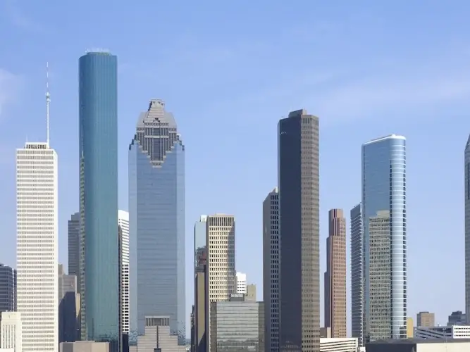 A city skyline with numerous skyscrapers under a blue sky.